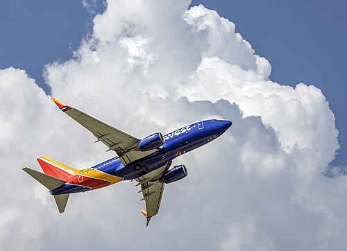 Southwest Airlines 737 climbing in front of a cumulus congestus cloud